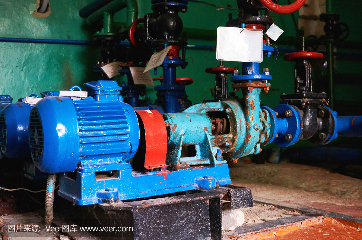 旧的、生锈的、有划痕的水泵,冷水管道上的电机漆成蓝色。